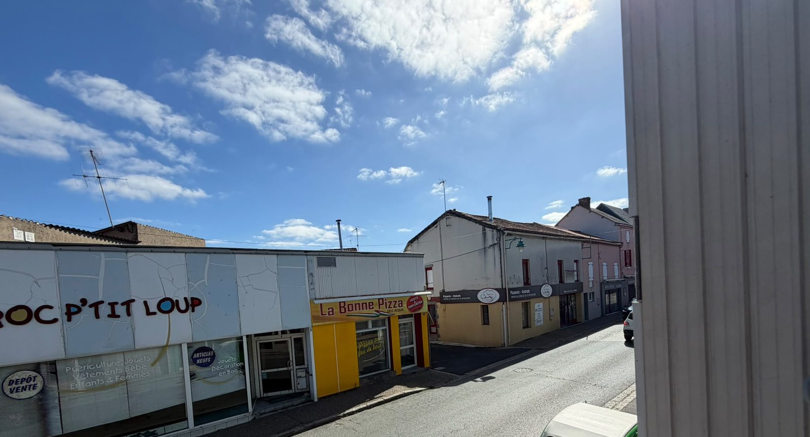 Vue depuis la fenêtre sur les commerces du centre-bourg